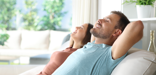 Couple détendu souriant, se penchant en arrière sur un canapé, les yeux fermés à Muret en Haute-Garonne 31
