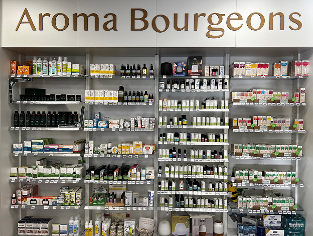Intérieur de magasin avec étagères remplies de produits d'aromathérapie sous l'enseigne Aroma Bourgeons à Muret en Haute-Garonne 31
