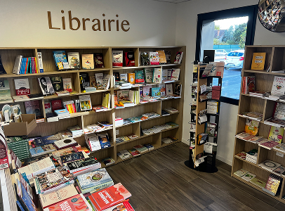 Librairie lumineuse avec des étagères en bois remplies de livres et un présentoir à Muret en Haute-Garonne 31